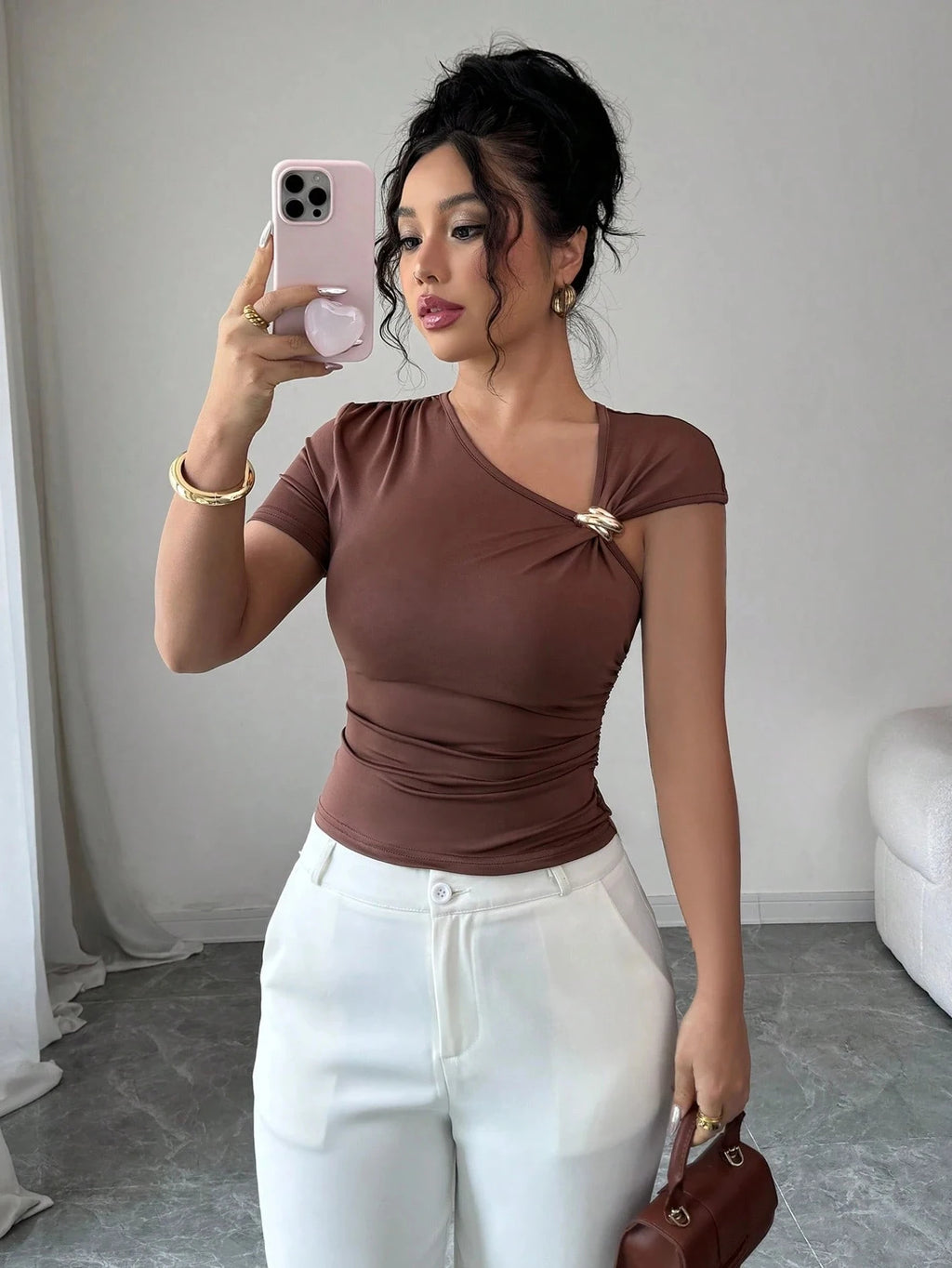 Blusa feminina marrom com decote assimétrico e detalhe metálico